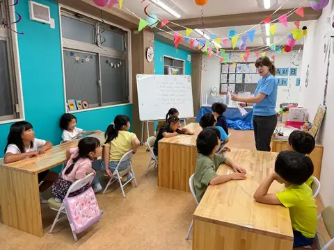 アフタースクールでタイダイ染めの説明を聞く小学生たち