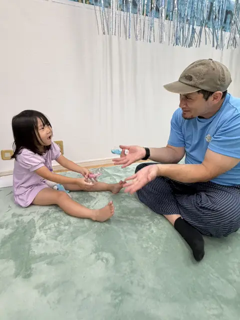 キンダースクールで先生と活動する子ども