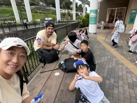 フィールドトリップで先生と記念撮影をする子どもたち
