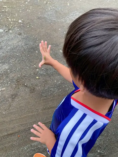 外で手を伸ばして遊ぶ男の子