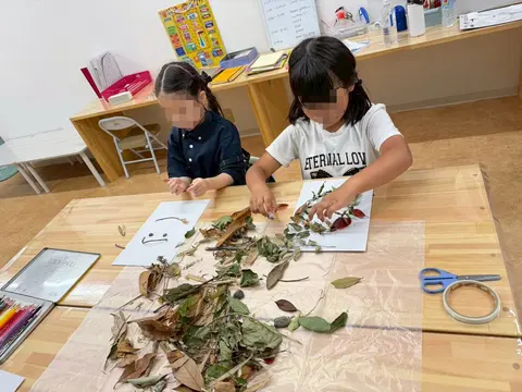 葉や枝を並べて自然工作に取り組む子どもたち