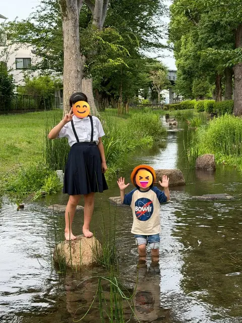 小川で水遊びをする子どもたち