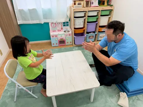 先生と手遊びを楽しむ子ども