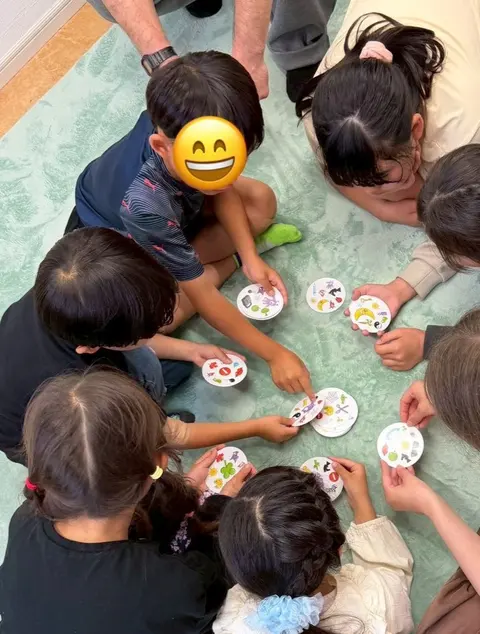 床に座って絵カードのゲームを楽しむ子どもたち