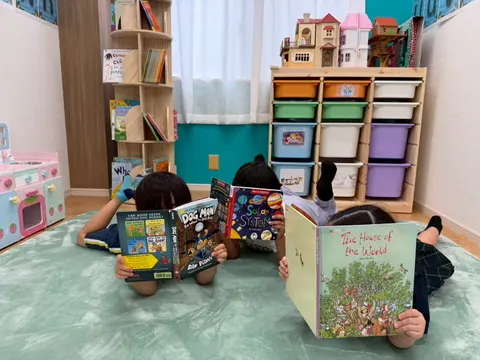 教室の床に寝転んで本を読む子どもたち