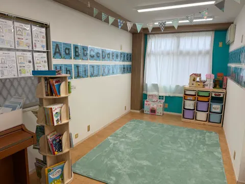 アルファベットの掲示と絵本棚がある明るい教室
