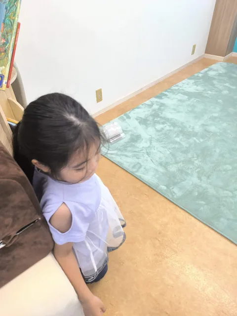 教室のクッションにもたれてくつろぐアフタースクールの子ども