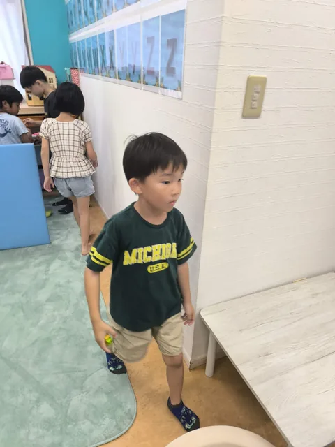 教室でカードを手に活動するアフタースクールの男の子