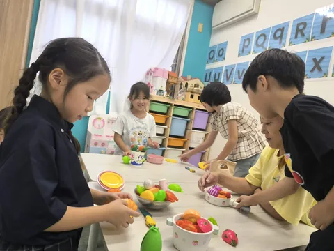 テーブルを囲んでおままごとを楽しむアフタースクールの子どもたち