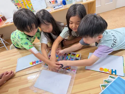 マグネットの文字を選んで単語を作るアフタースクールの子どもたち