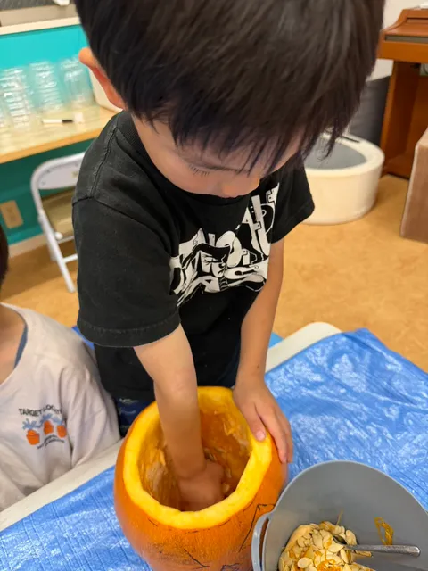かぼちゃの中に手を入れて種を探す男の子