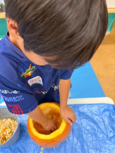 かぼちゃの中身を手でかき出す男の子