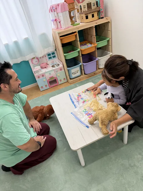 カラフルな感触袋で遊ぶ親子と見守る先生