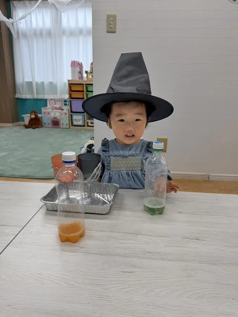 魔女の帽子をかぶって色水あそびをする女の子