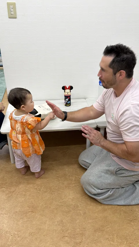プリスクールで先生とハイタッチする赤ちゃん