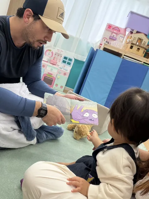 先生にハロウィンの絵本を読んでもらう子ども