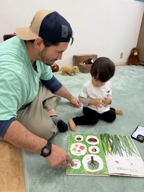 プリスクールで先生と英語の絵本を見ながら単語を覚える赤ちゃん