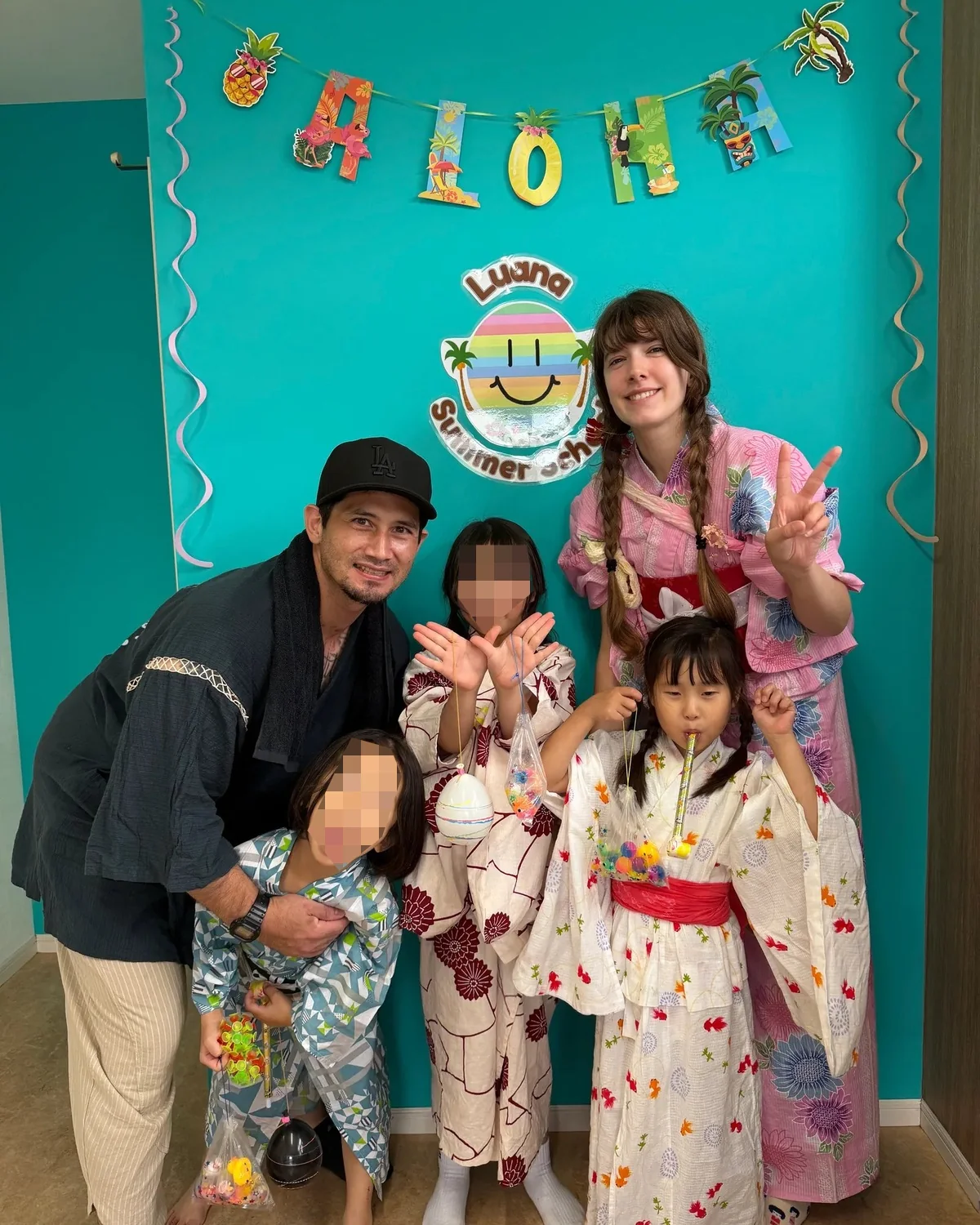 夏祭りの活動で先生と一緒に写真を撮る子どもたち