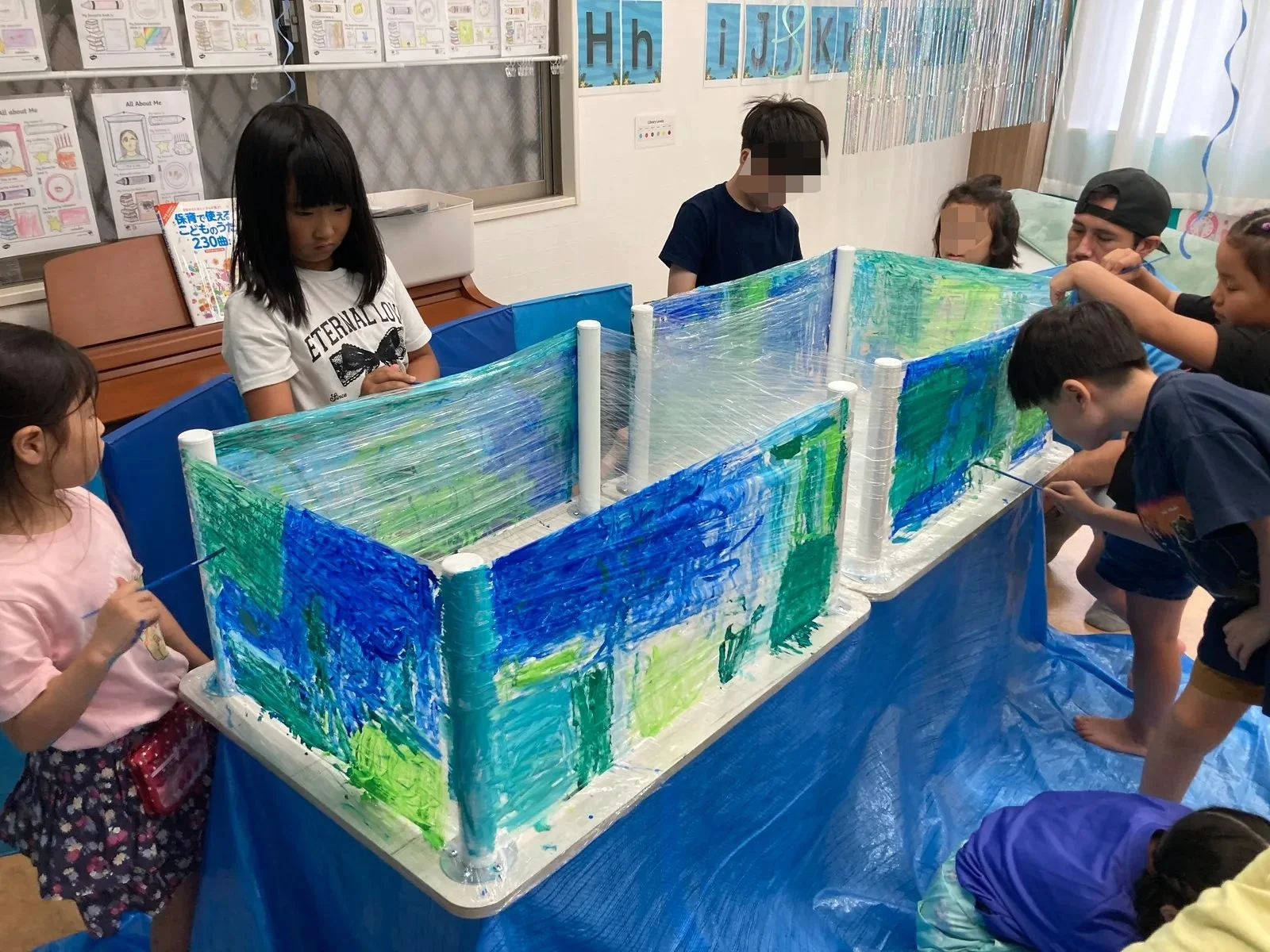 海をテーマにした大きな共同作品を作る子どもたち