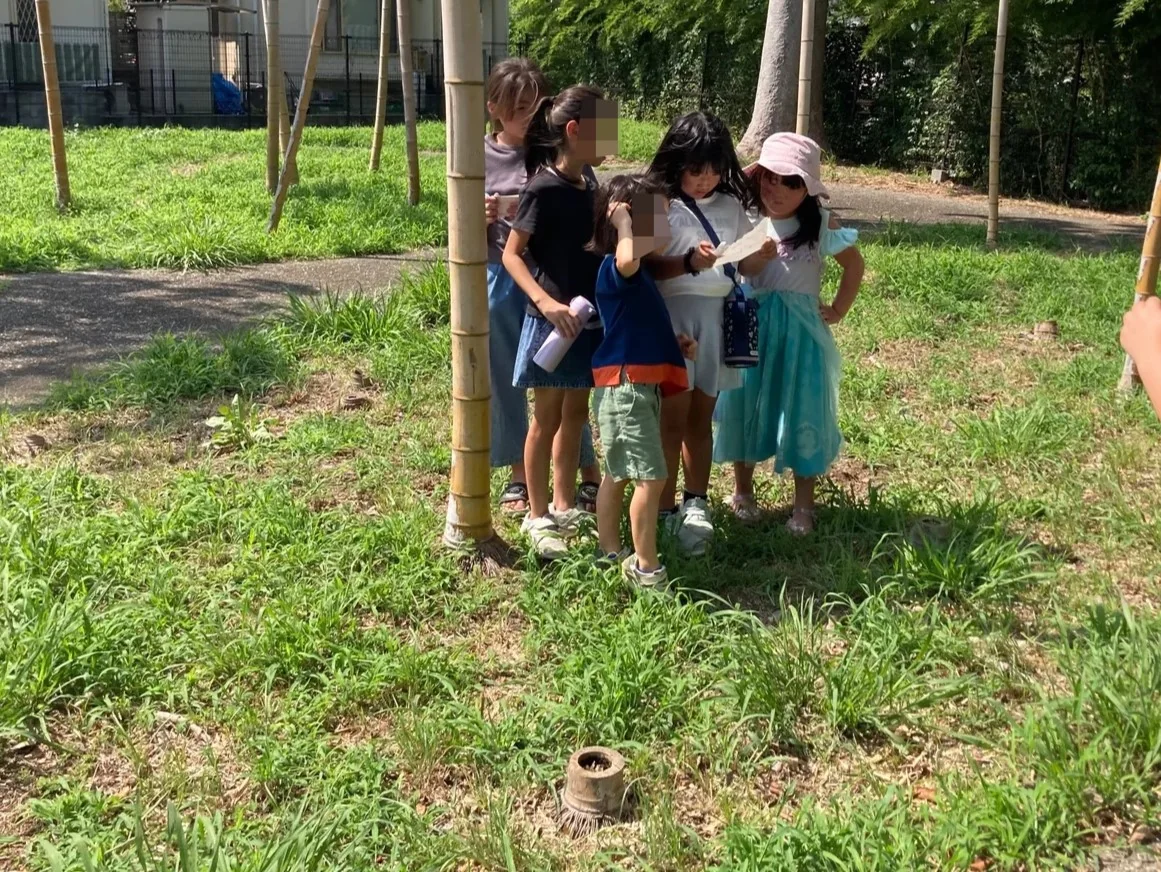 先生と子どもたちが屋外でナビゲーション活動に取り組む様子