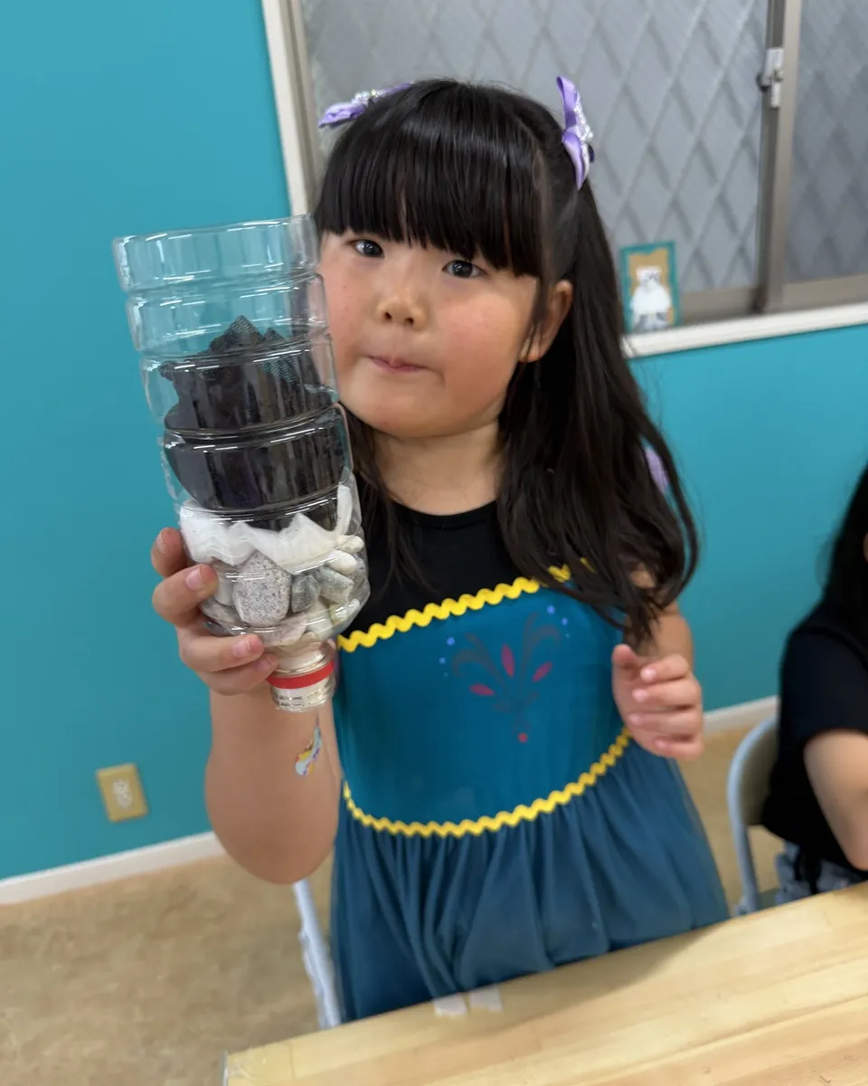 資源の使い方をテーマに作った装置を持つ子ども